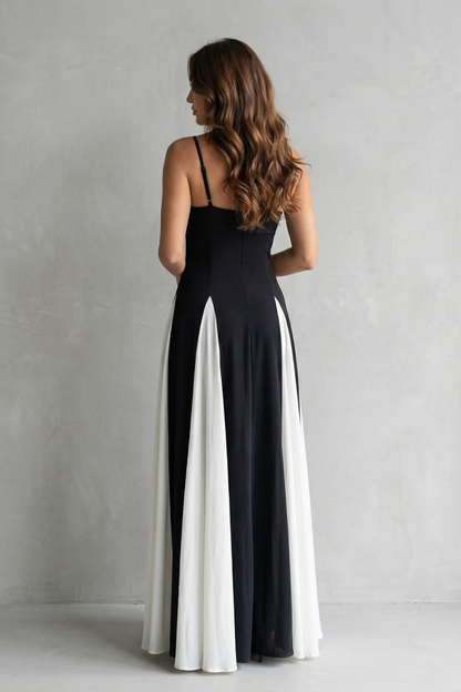 Back view of the black and white maxi dress, highlighting the thin straps and elegant flow of the skirt.