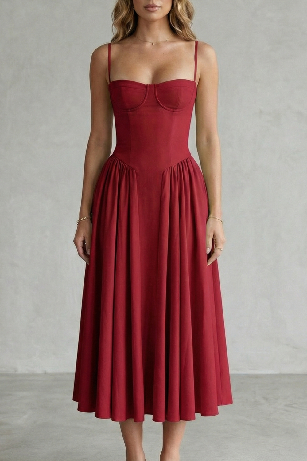 Bright red structured sweetheart neck midi dress with fine spaghetti straps and a gathered full skirt, ideal for vacation outfits.
