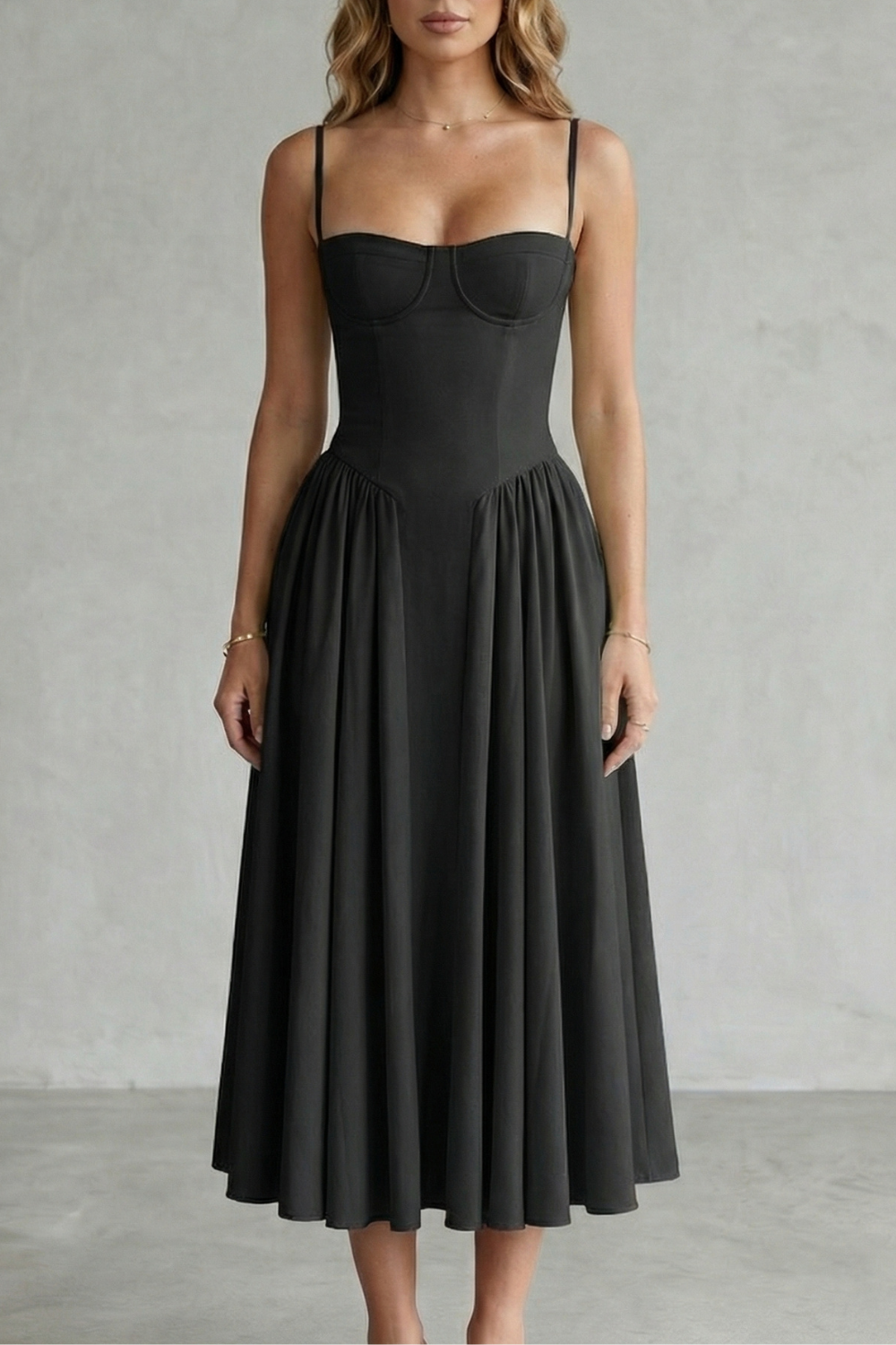 Black structured sweetheart neck midi dress with spaghetti straps and a full pleated skirt, elegant for evening wear.