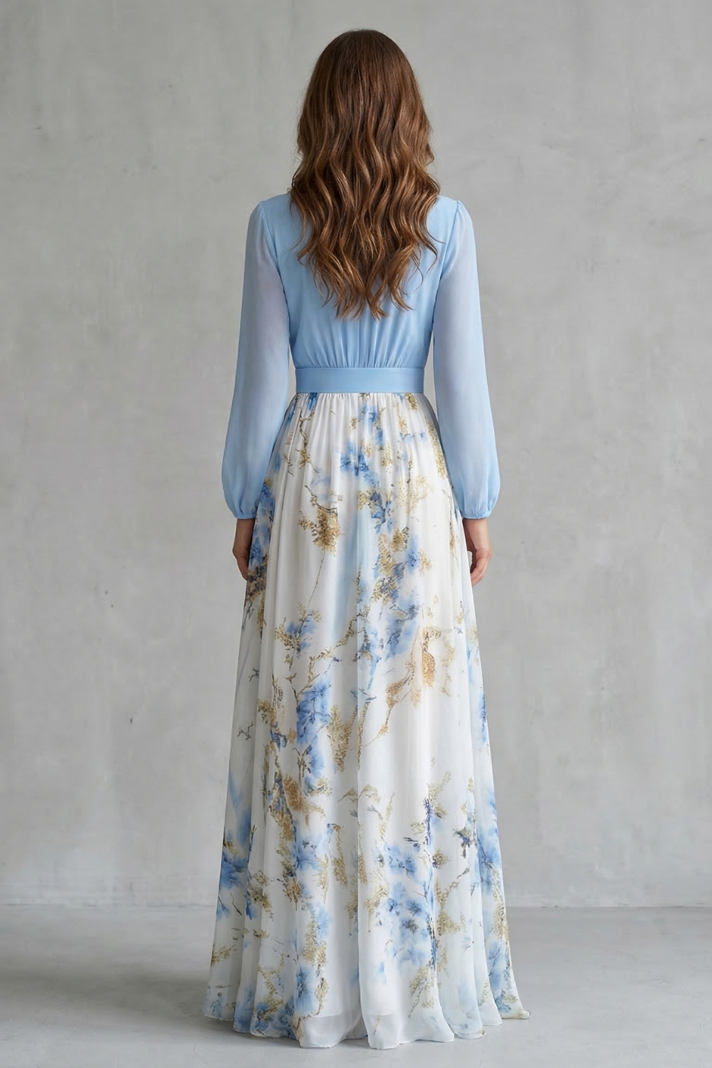 Back view of a women's summer floral V-neck maxi dress, highlighting the light blue long-sleeve top and the white skirt with blue and gold floral print.
