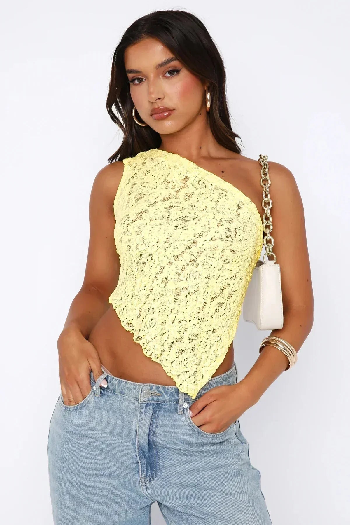 Yellow one shoulder lace crop top with handkerchief point hem, front view paired with jeans