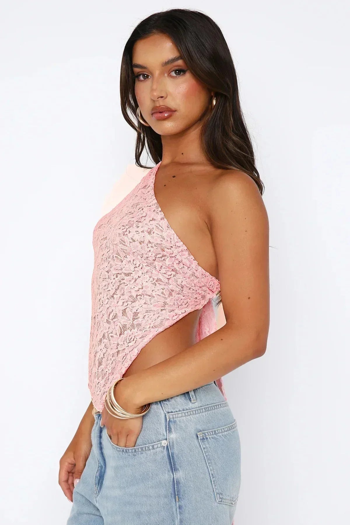 Side view pink lace one shoulder crop top with sheer lace texture and handkerchief hem