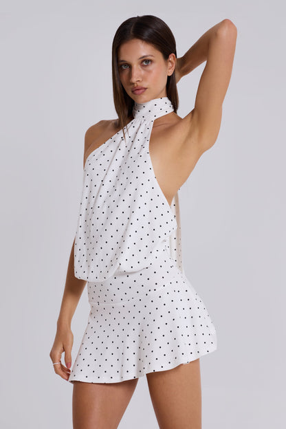 White polka dot halter neck bodycon mini dress with draped asymmetric top and fitted skirt