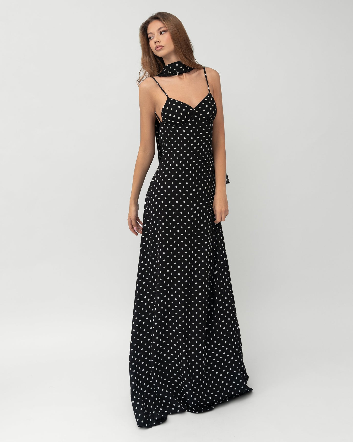 Angled front view of polka dot sweetheart maxi dress with matching neck scarf and open back detail