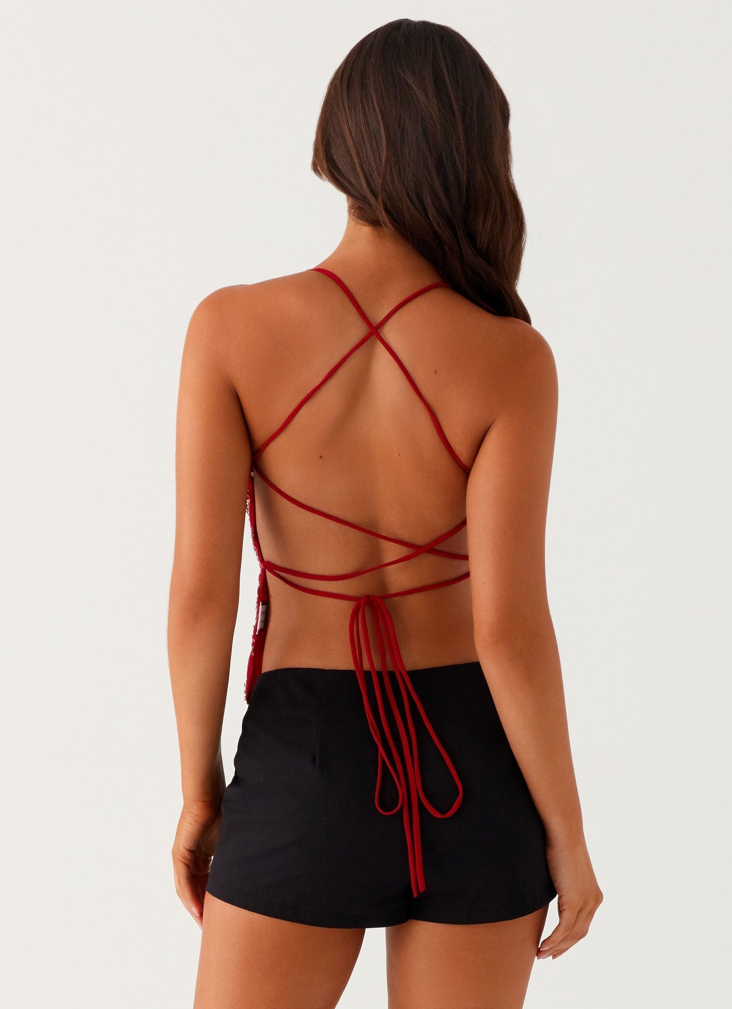 Back view red V-neck crop top with crisscross spaghetti straps and long tie closure