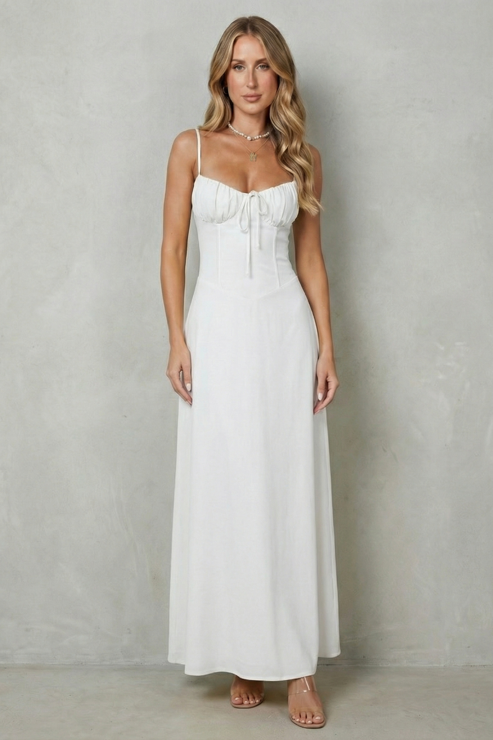 Full-length front view of a women's pristine white maxi dress, featuring a sweetheart neckline and a flowing skirt, perfect for a beach dress.