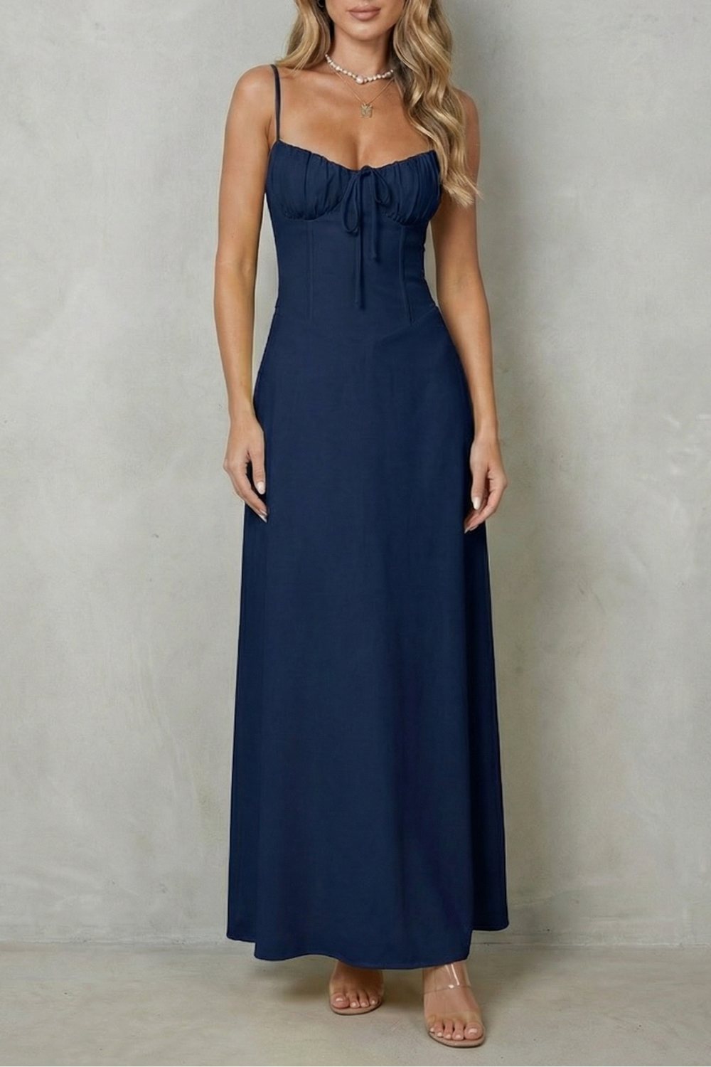 Front view of a women's navy blue sweetheart neck maxi dress with a tie-front detail on the bodice, suitable for elegant wedding guests.
