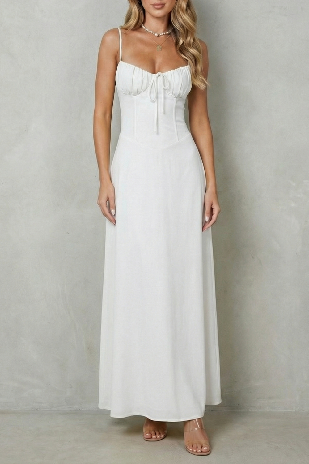 Front view of a women's white sweetheart neck maxi dress with a ruched bodice and delicate straps, a beautiful white silk dress option.
