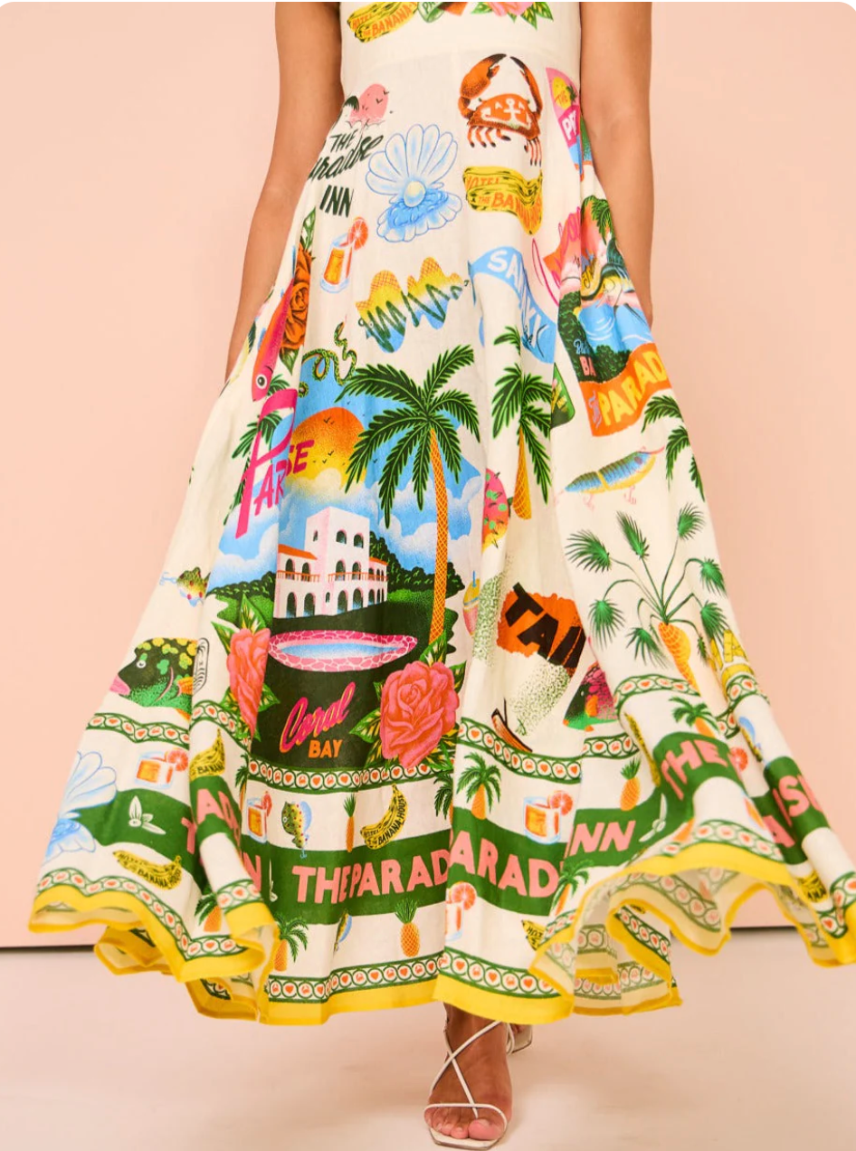 Flowing skirt of a women's tropical print maxi dress, showcasing the vibrant patterns and yellow-trimmed hem.