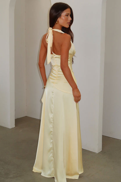 Side back view of pale yellow satin maxi dress with open back, neck tie and fitted corset waist