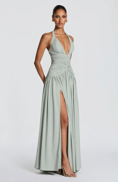 Sage green halter maxi dress angled view showing fitted ruched torso and high side slit