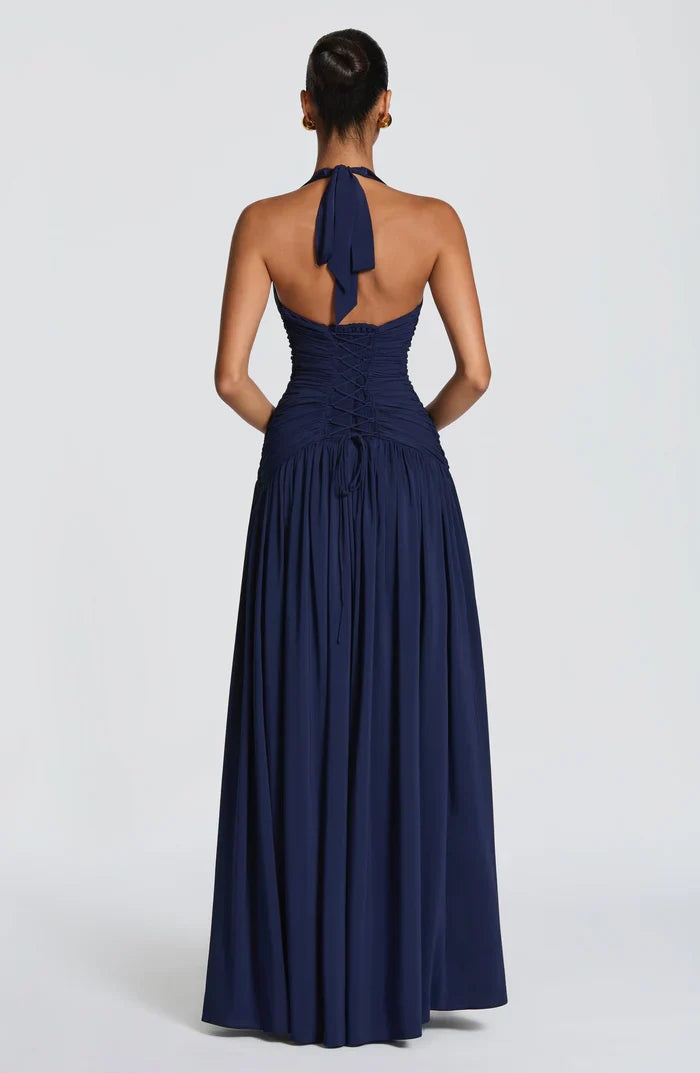 Back view of navy halter maxi dress showing tie-neck and lace-up corset back with gathered skirt