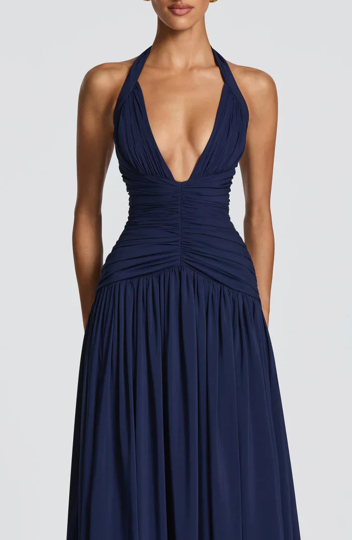 Close-up of navy halter maxi dress bodice with plunging V neckline, pleated cups, and ruching