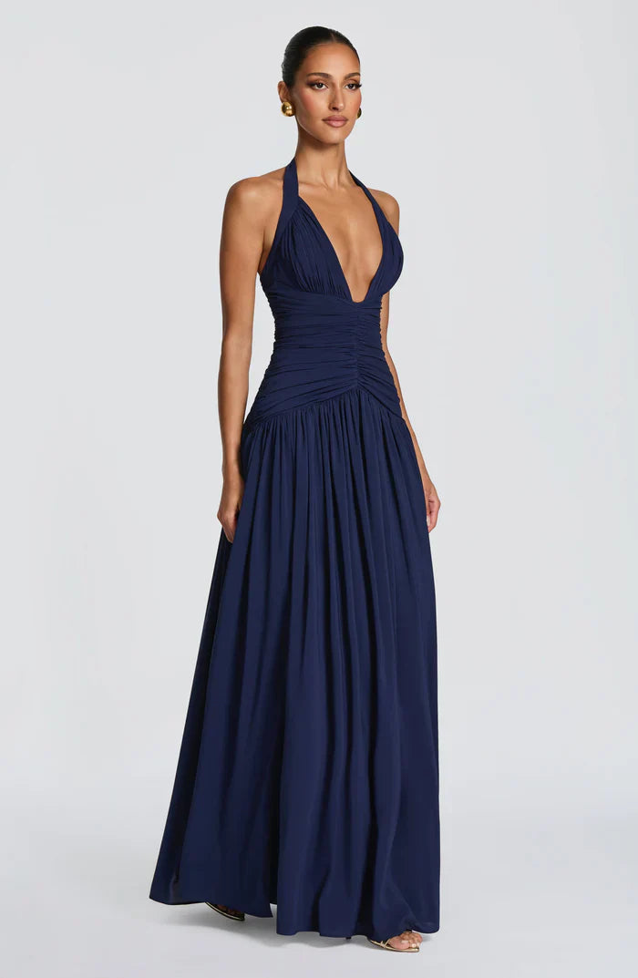 Side view navy summer wedding guest halter maxi dress highlighting fitted waist and full-length skirt