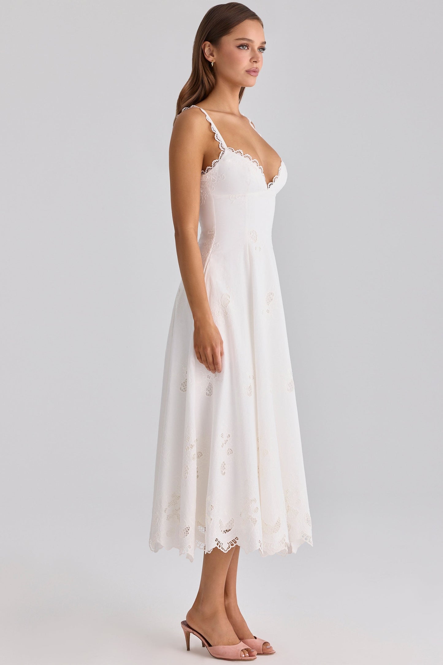 Side view of white maxi dress with lace-edged straps, fitted bodice, and flared skirt