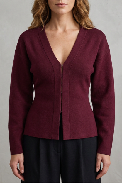 Close-up front view of a women's maroon knit v-neck long sleeve top with hook-and-eye closure.