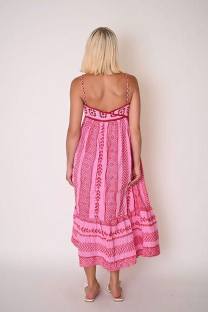 Women pink printed maxi dress back view with straight back neckline, narrow straps, gathered skirt, and tiered hem detail