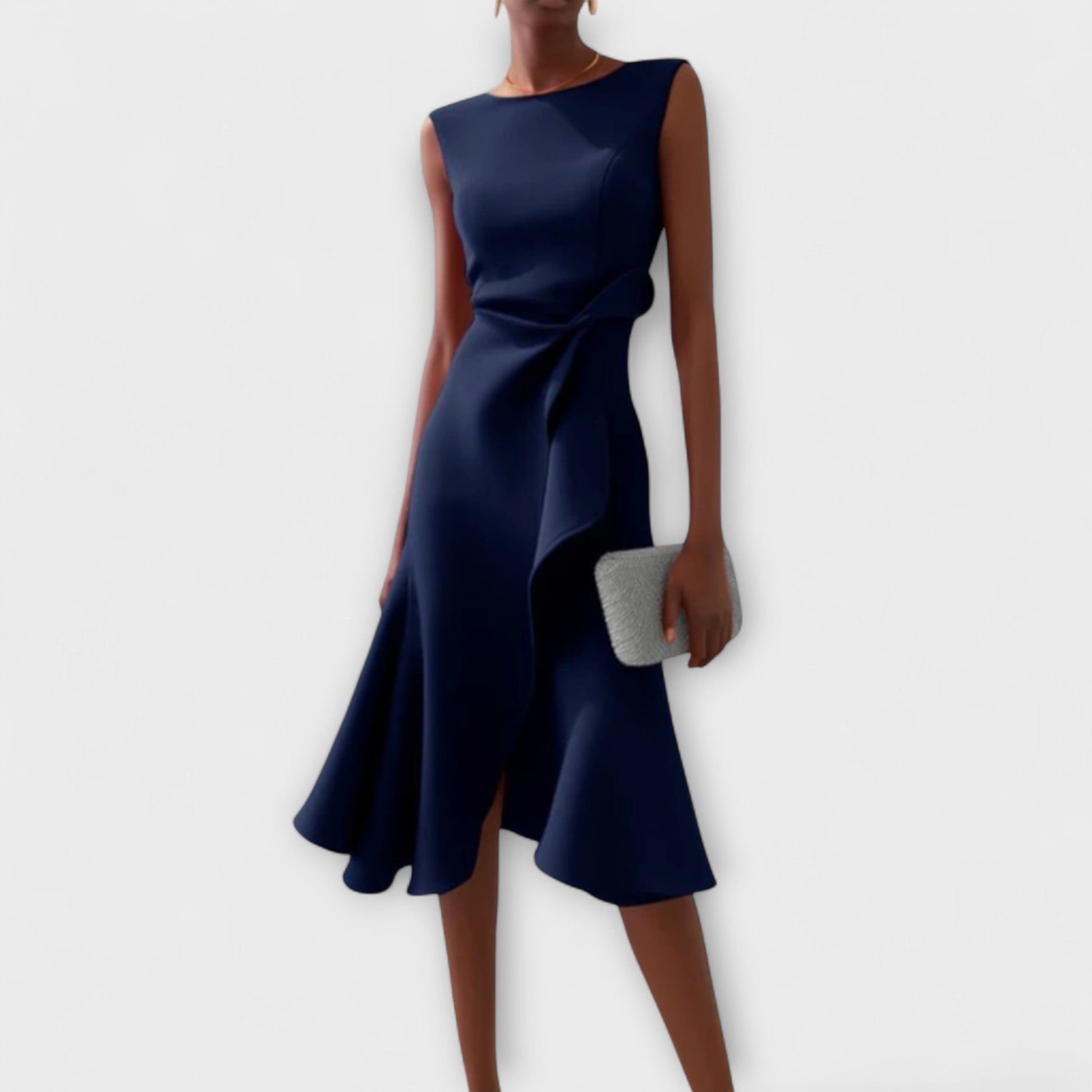 Navy blue sleeveless midi dress featuring an asymmetric ruffled hem and a delicate tie-waist detail, perfect for vacation outfits.