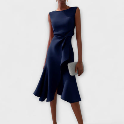 Navy blue sleeveless midi dress featuring an asymmetric ruffled hem and a delicate tie-waist detail, perfect for vacation outfits.