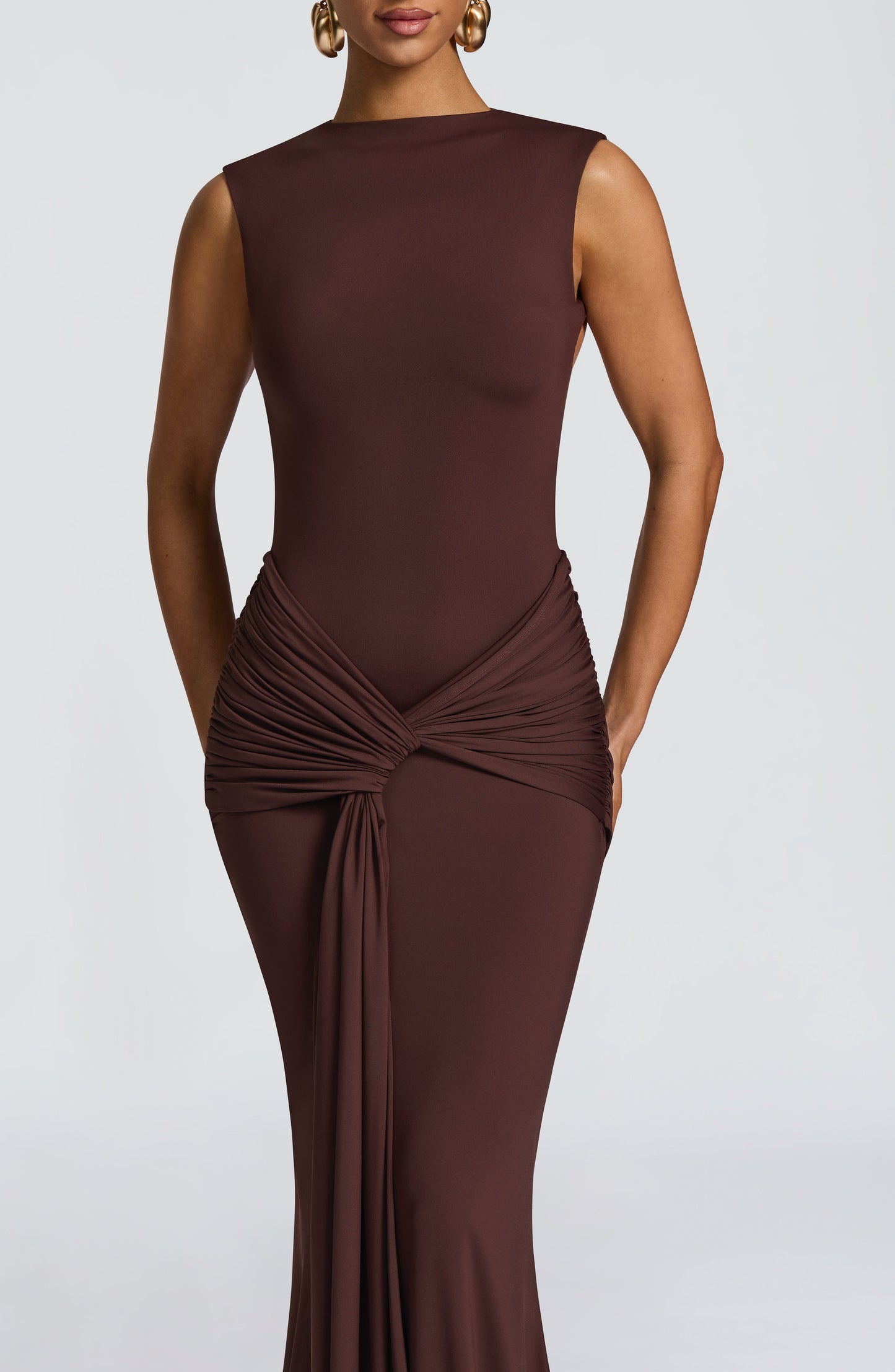 Close-up of chocolate brown sleeveless maxi dress with ruched waist twist knot detail