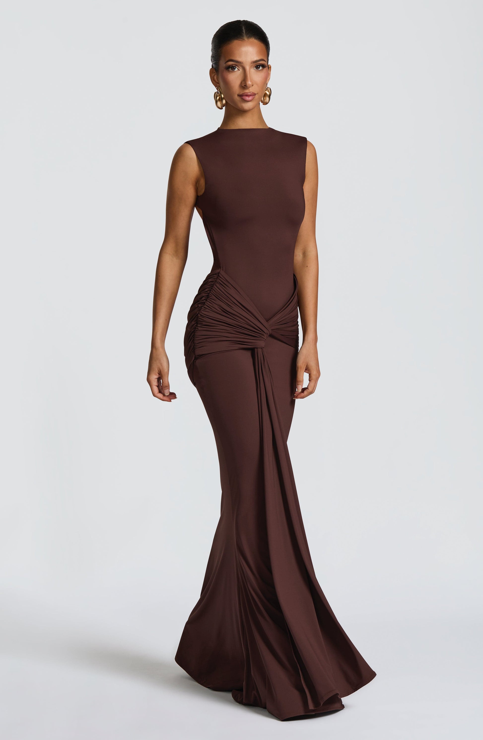 Front view chocolate brown sleeveless backless ruched maxi dress with floor-length skirt