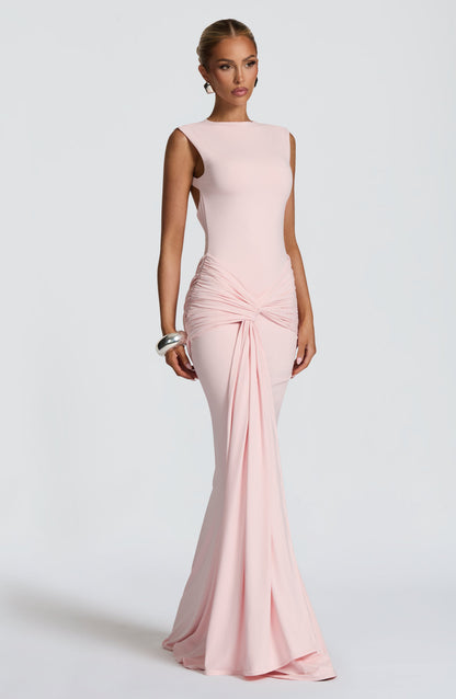 Blush pink bodycon maxi dress in three-quarter pose, highlighting ruched waist and floor-length hem