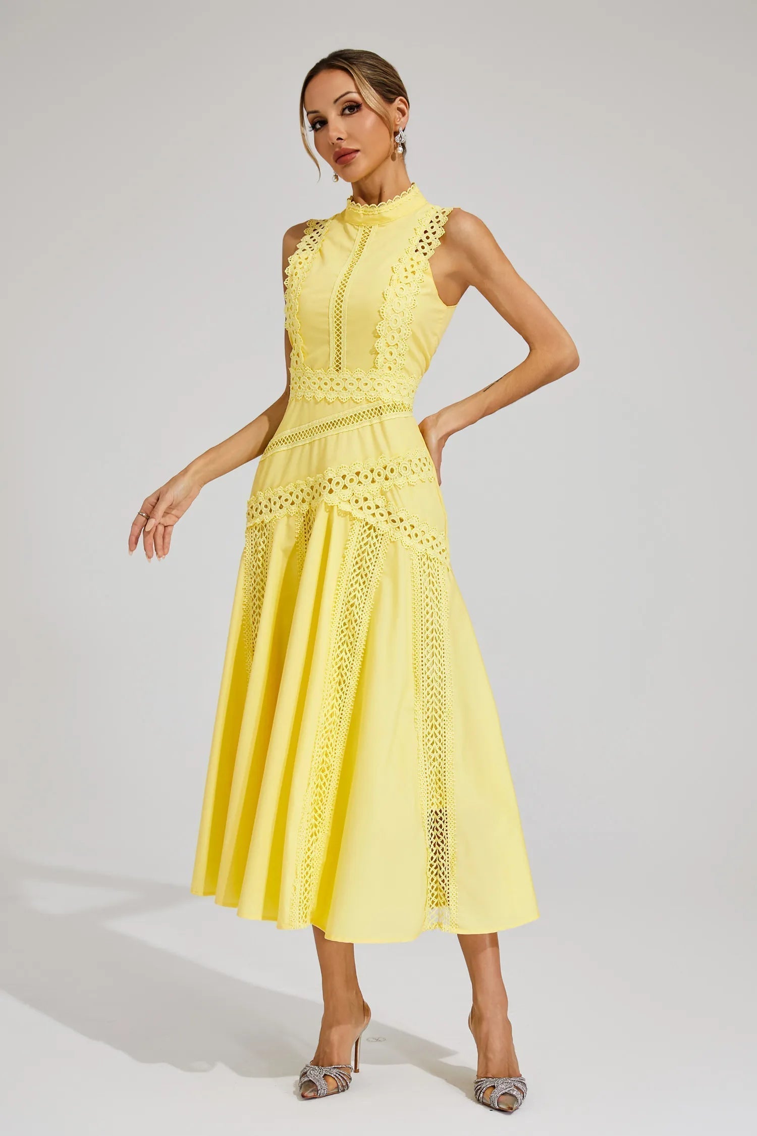 Side view of a women's yellow high neck midi dress with delicate cutwork lace inserts and a flowing A-line skirt.
