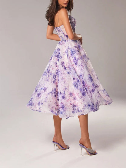 Back view of the women's floral midi dress in purple and blue print, showing the elegant flow of the skirt, ideal for wedding guests.