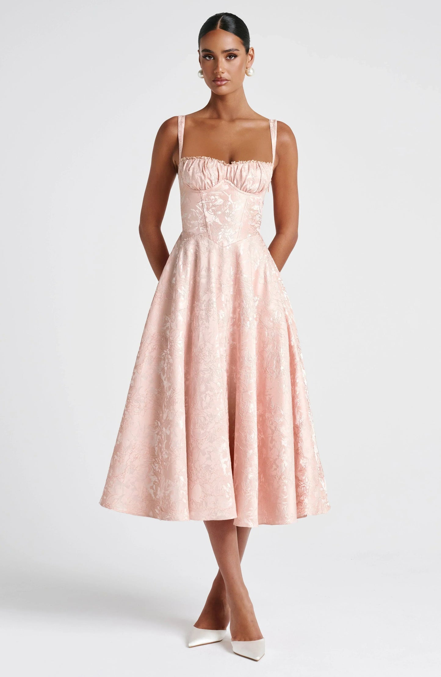 Front view blush wedding guest floral midi dress with corset seams, wide straps, and fit-and-flare skirt