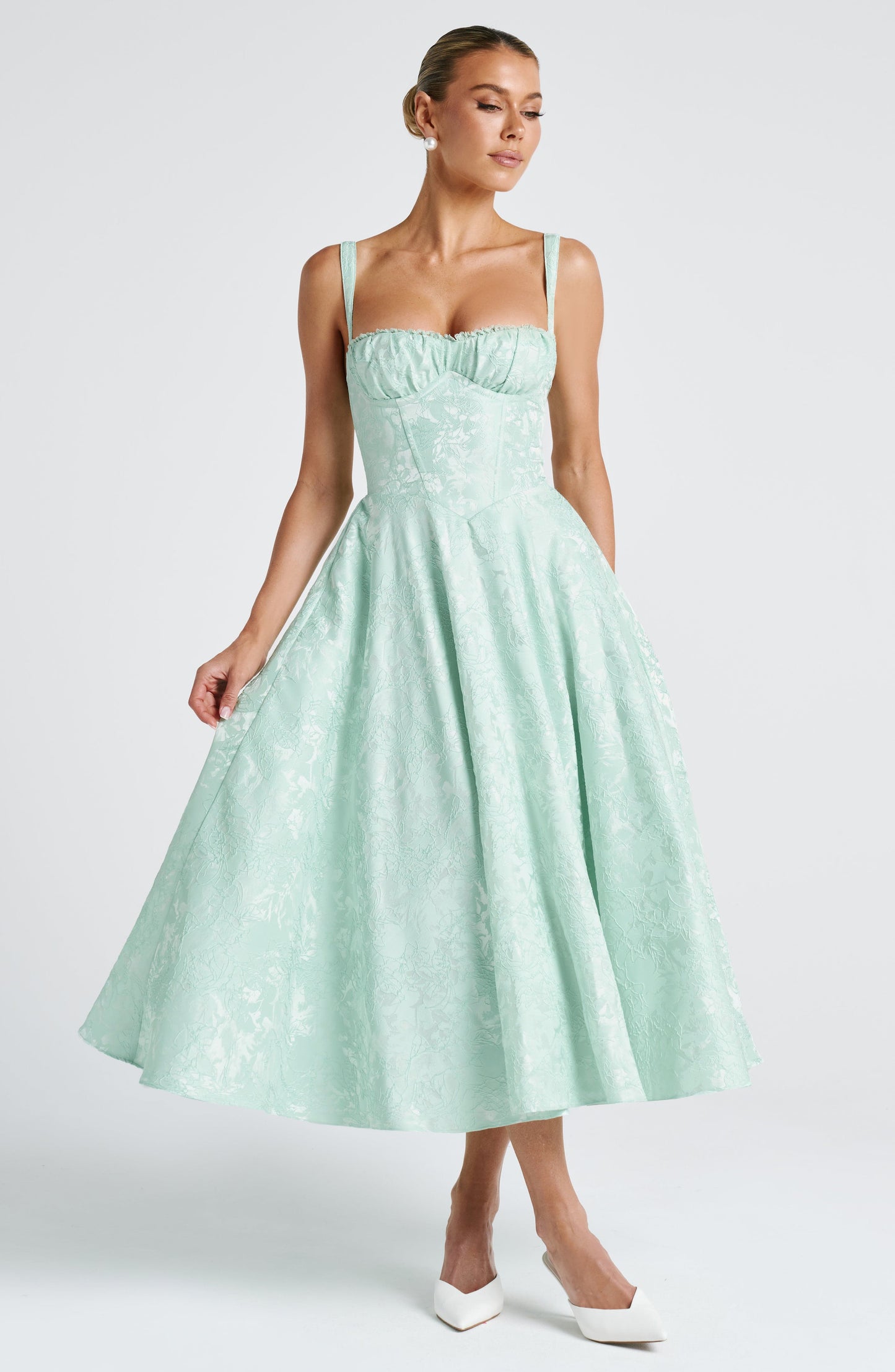 Mint green floral square neck midi dress with structured corset bodice and fit-and-flare skirt, hem held out