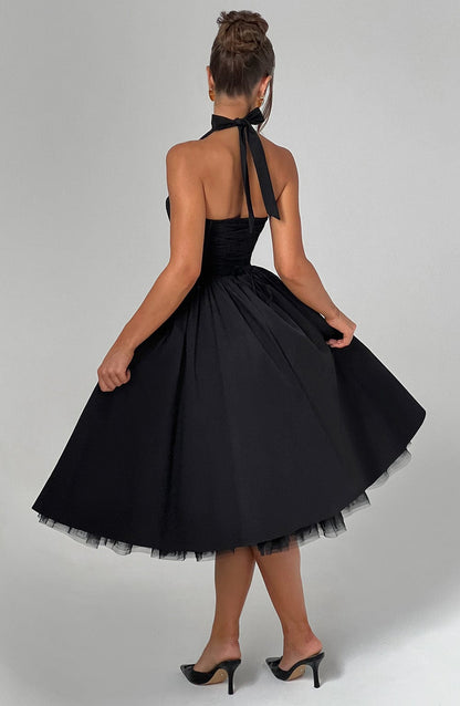 Back view of the black halter neck midi dress, displaying the tie-back detail and the elegant full skirt with a tulle underskirt.