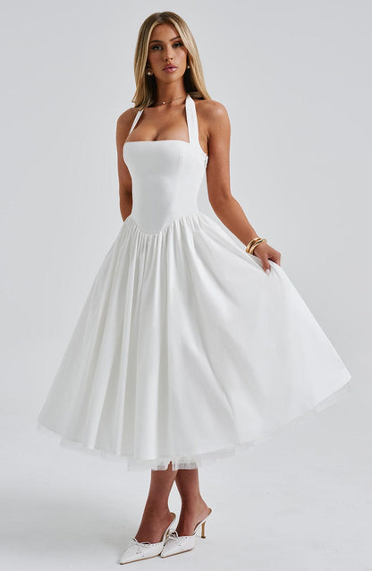 White halter neck midi dress with a fitted bodice and a flowing A-line skirt, showcasing the elegant silhouette for wedding guests.