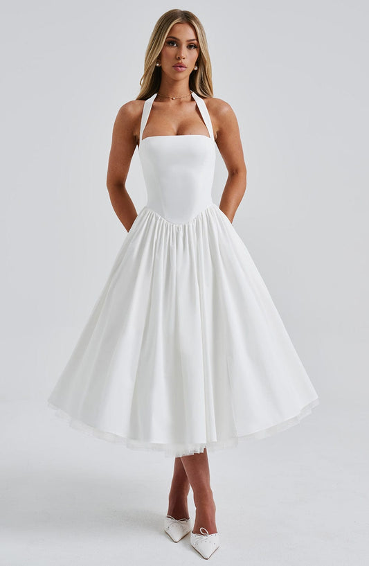 Elegant white halter neck midi dress with a square neckline and full pleated skirt, perfect for wedding guests.