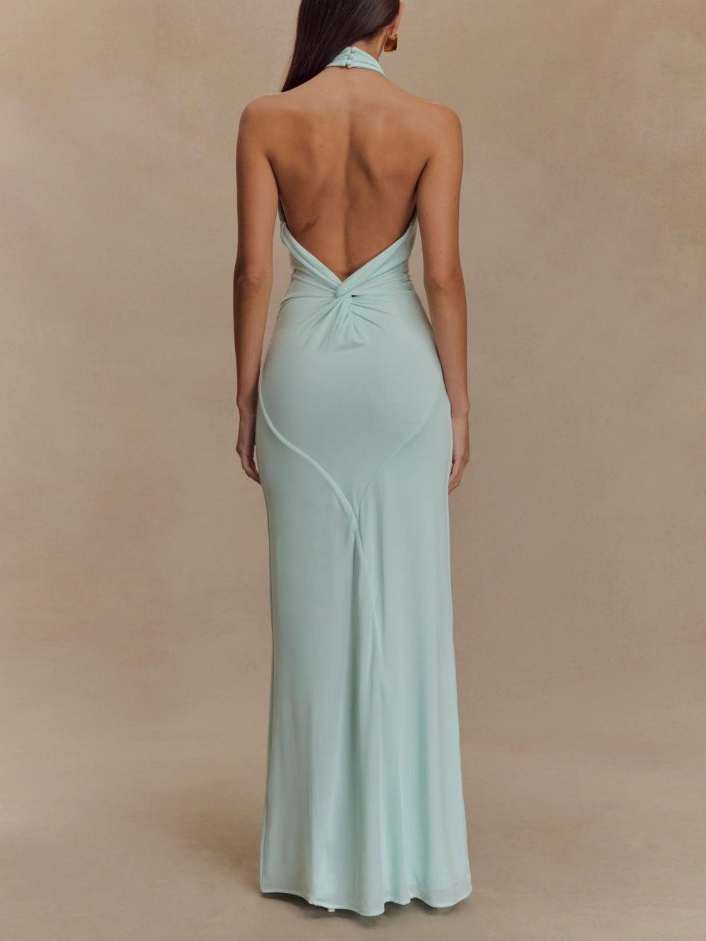 Back full-length view of mint halter ruched maxi dress with deep V open back and twist detail