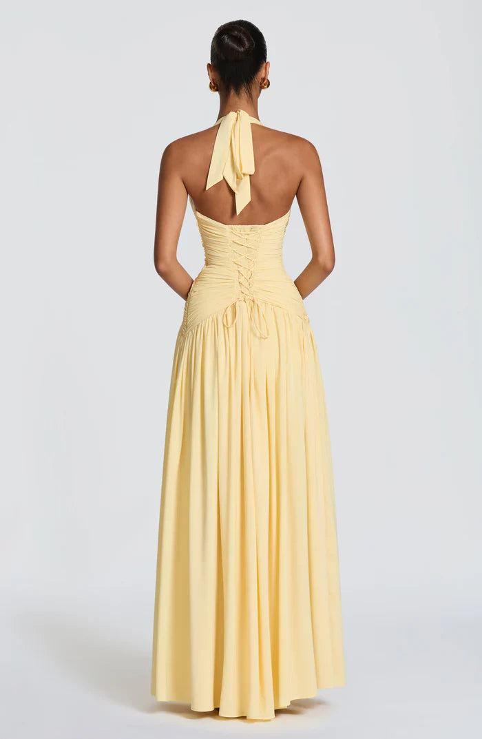 Back view of pale yellow halter V neck backless maxi dress with lace-up corset and ruched waist
