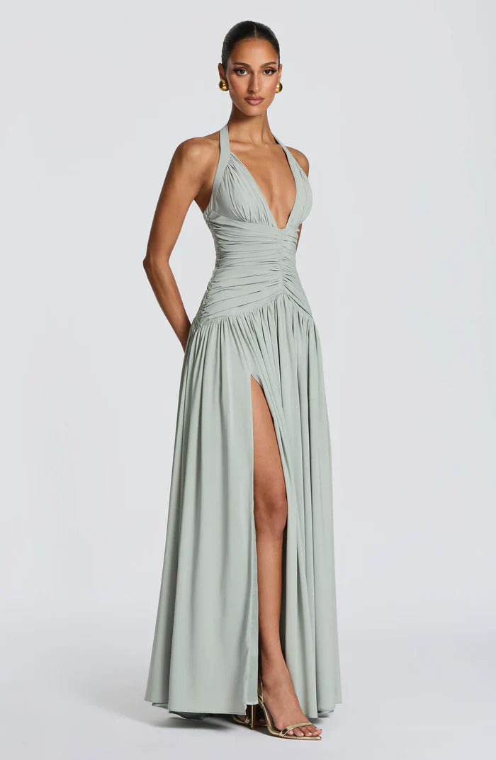 Three-quarter view sage green halter V neck maxi dress showing ruched midsection and side slit