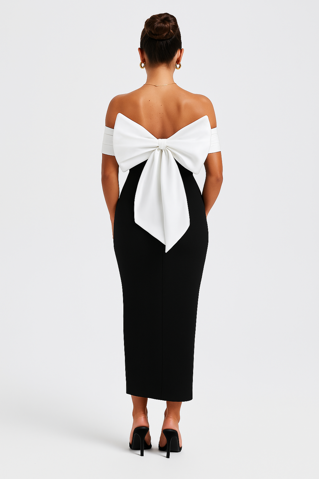 Rear view of a black off-shoulder midi dress featuring a large white bow detail, ideal for wedding guests.