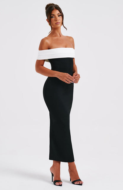 Side profile of a women's black off-shoulder midi dress with a white band, showcasing the bodycon fit.