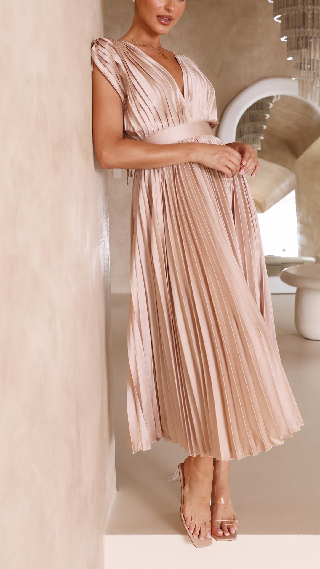 Close-up of the champagne pleated V-neck midi dress, emphasizing the texture of the pleats and the elegant silhouette, a sophisticated wedding guest dress.