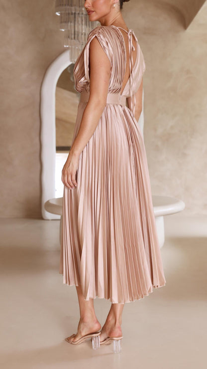 Back view of a champagne pleated midi dress, showing deep V-back and tie detail, a stylish wedding guest dress.