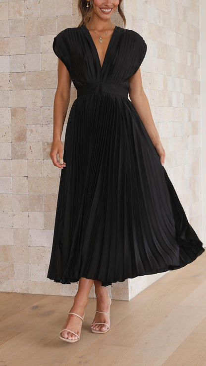 Black pleated midi dress with a v-neck and cap sleeves, with a slight lift of the skirt, elegant for wedding guests.