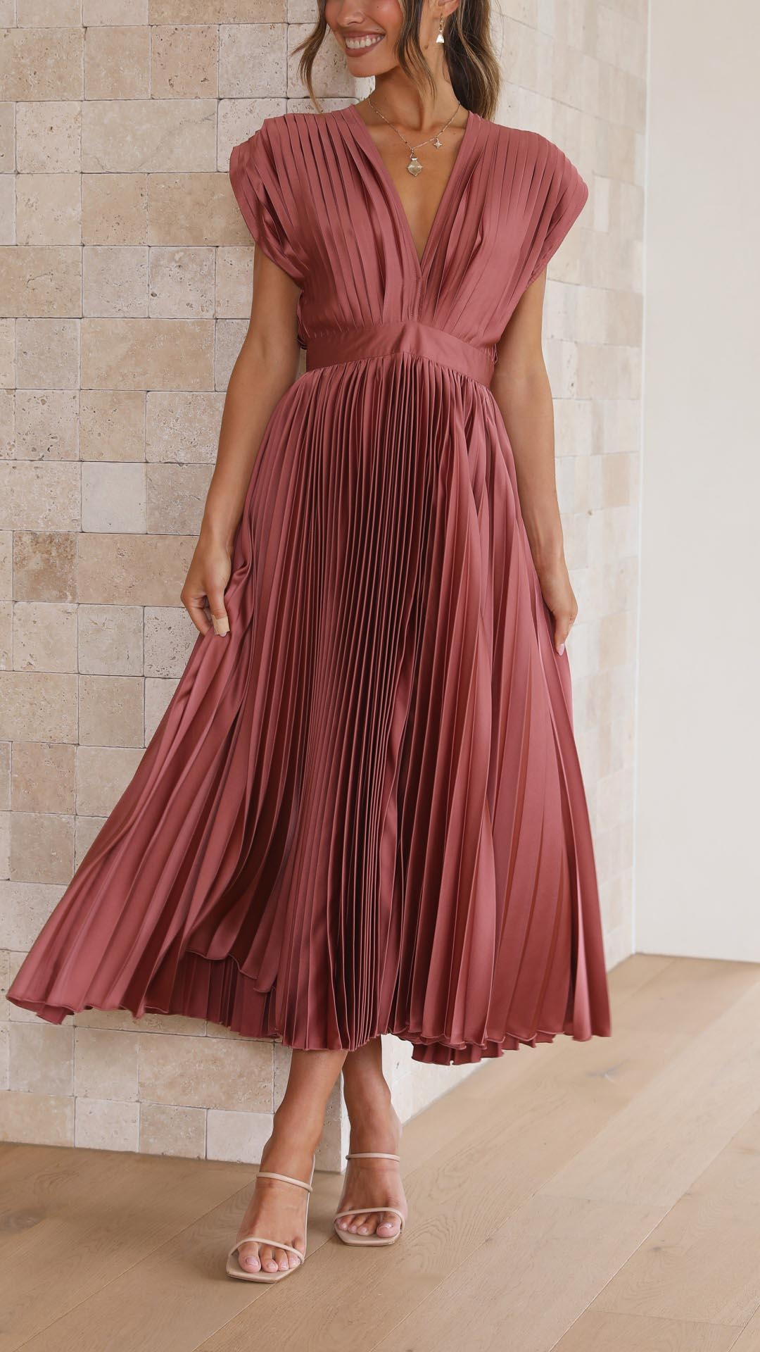 Flowing rosewood pleated midi dress for women, highlighting the movement of the skirt and the elegant V-neck design, suitable for wedding guests.