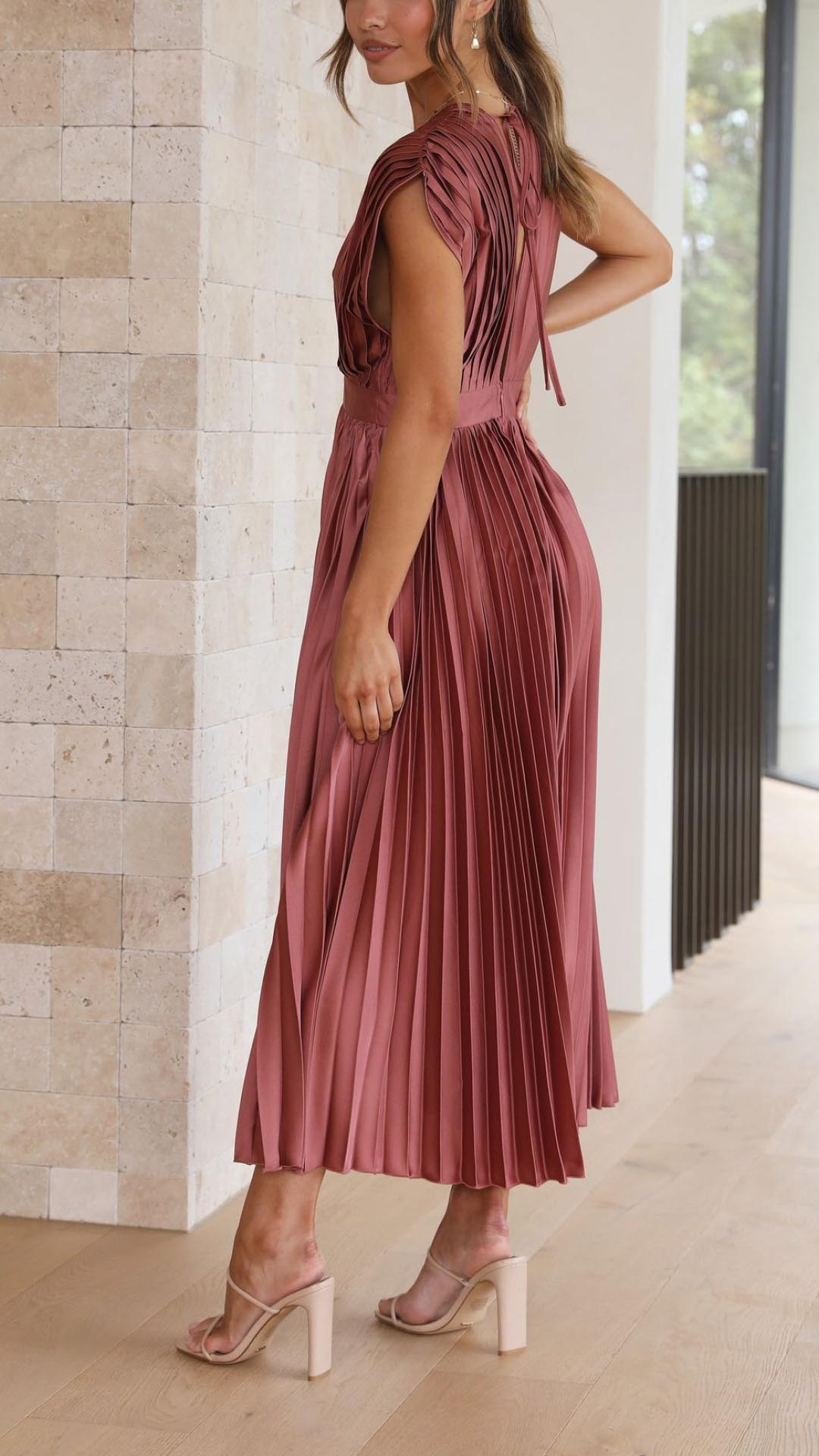 Side view of the rosewood pleated V-neck midi dress, revealing the intricate pleating details and a tie-back feature, an elegant dress for wedding guests.