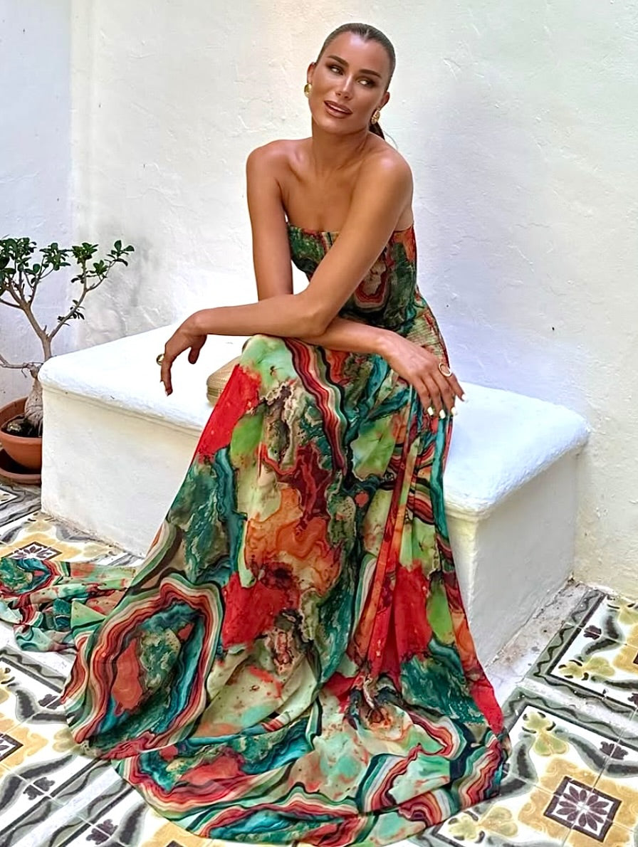 Strapless printed maxi dress with dramatic train, multicolor abstract pattern shown while seated