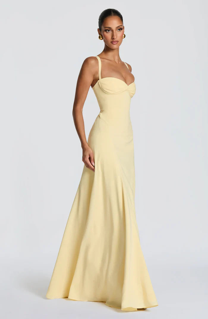 Pale yellow wedding guest maxi dress with sweetheart neckline, ruched bust, and fitted corset, side angle