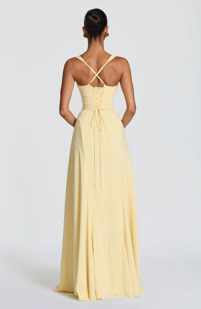 Back view of pale yellow corset maxi dress with crisscross straps and lace-up ruched back detailing