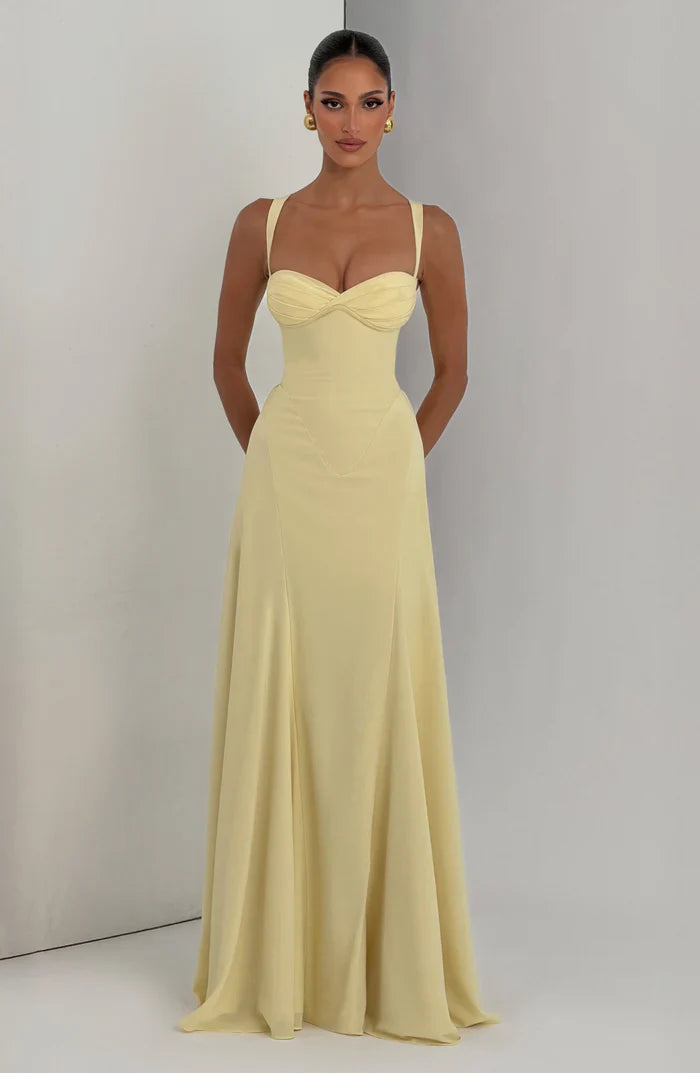 Pale yellow sweetheart corset maxi dress shown full length with soft drape and flared hem, front view