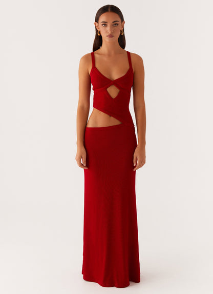 Front view of a red knit maxi dress with criss-cross bodice and strategic side cut-outs, an elegant dress for wedding guests.