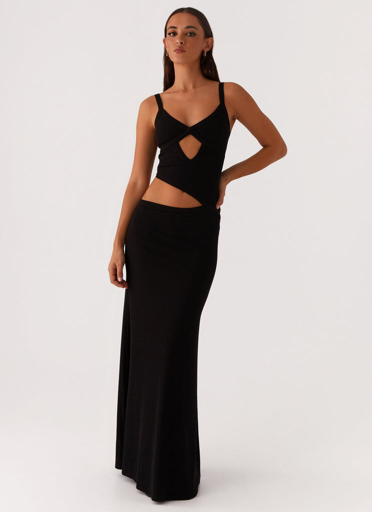 Front view of a black knit maxi dress with a criss-cross bodice and side cut-outs, a versatile midi dress for women.