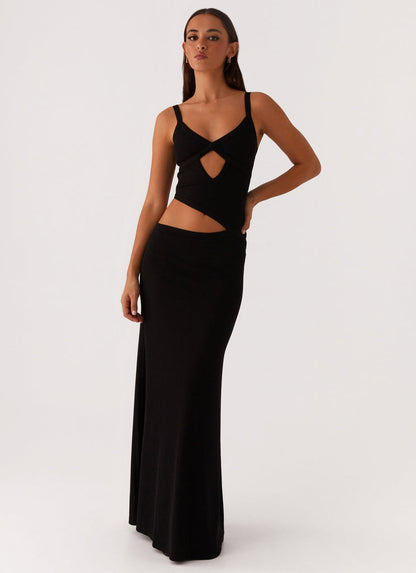 Front view of a black knit maxi dress with a criss-cross bodice and side cut-outs, a versatile midi dress for women.